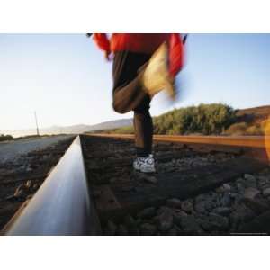  An Athlete Runs on Railroad Tracks Toward the Mountains 