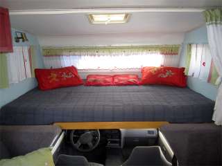   the motorhome. A large, cozy queen size bed tops the drivers cabin