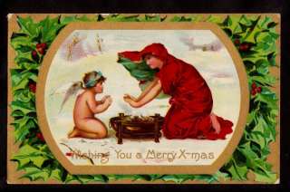 early woman in red & child angel warming by fire christmas postcard 