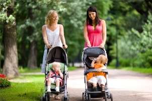 Two mothers on a walk with babies in strollers