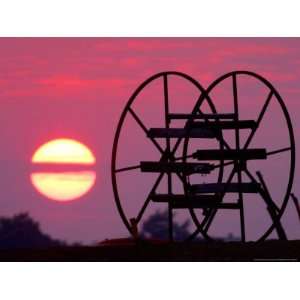  Farm Equipment is Silhouetted by a Setting Sun 